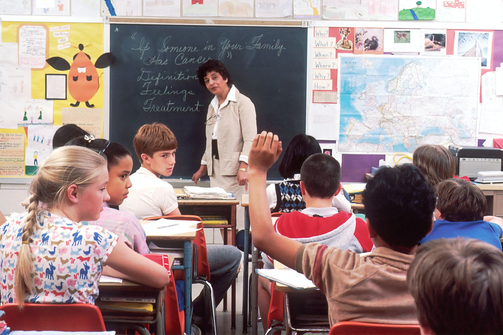 Student in classroom raising hand to ask a question